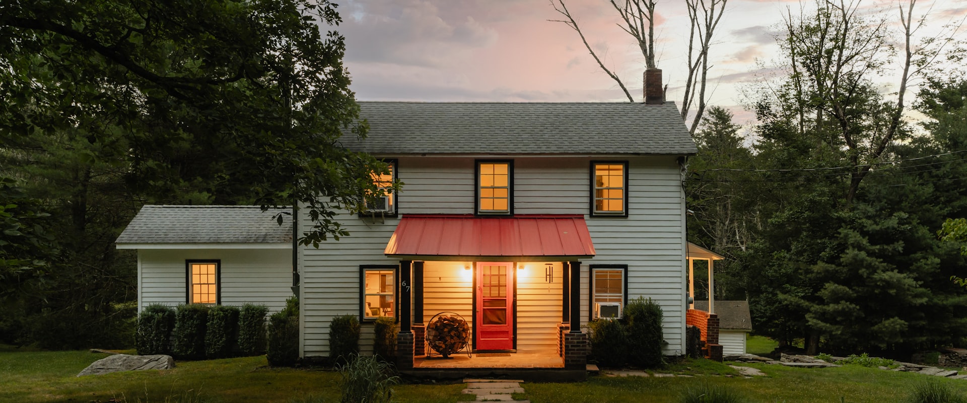 A house at dusk, lights on.